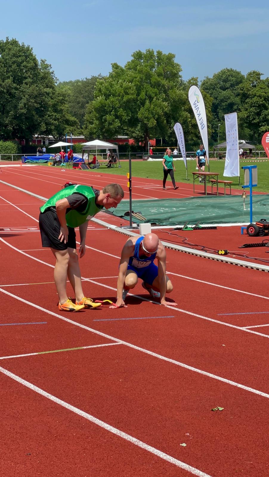 Mein Guide Simon spricht mit mir hockend nach dem Rennen.